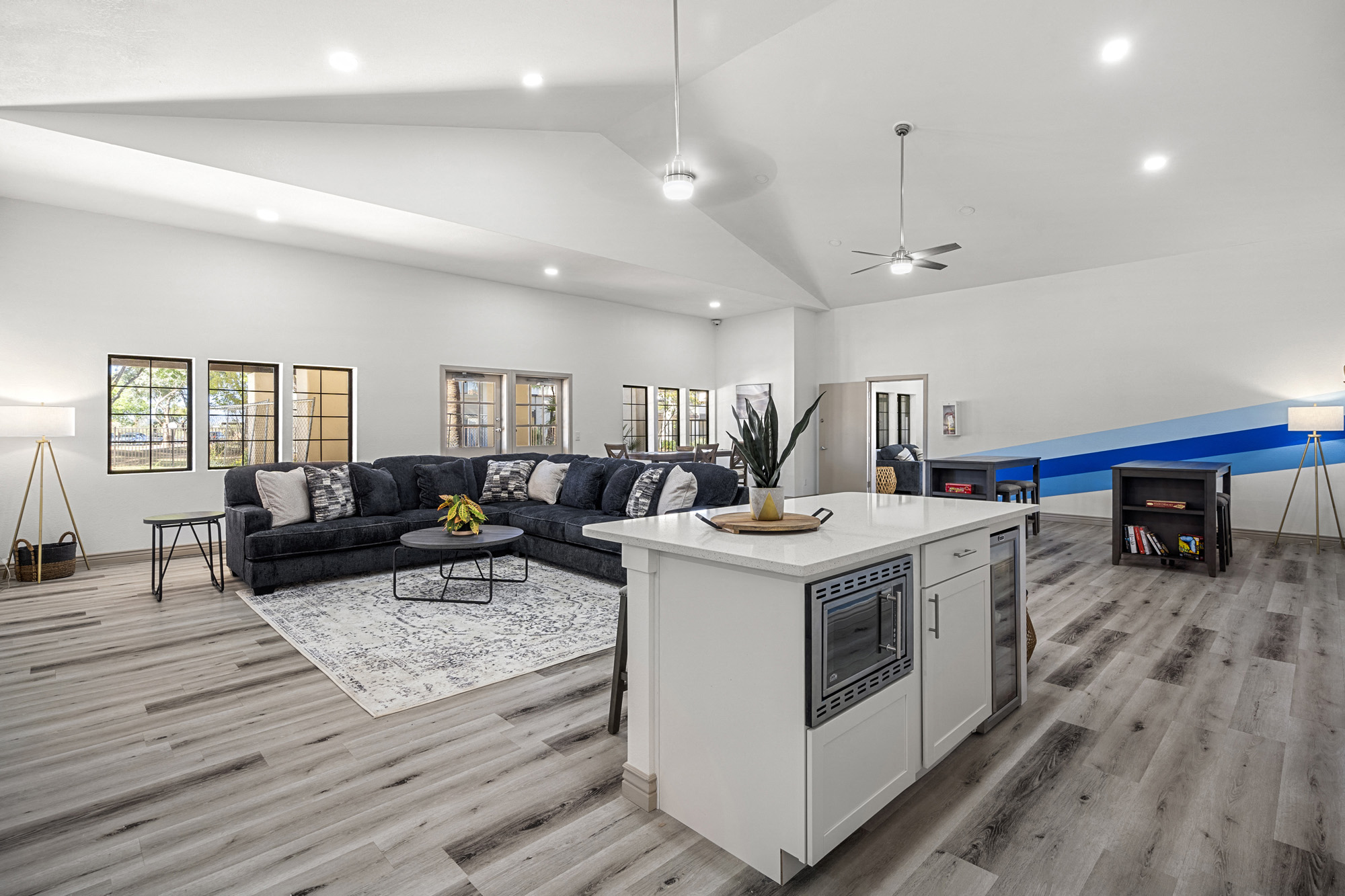 A modern living room with a black couch and a white kitchen island.