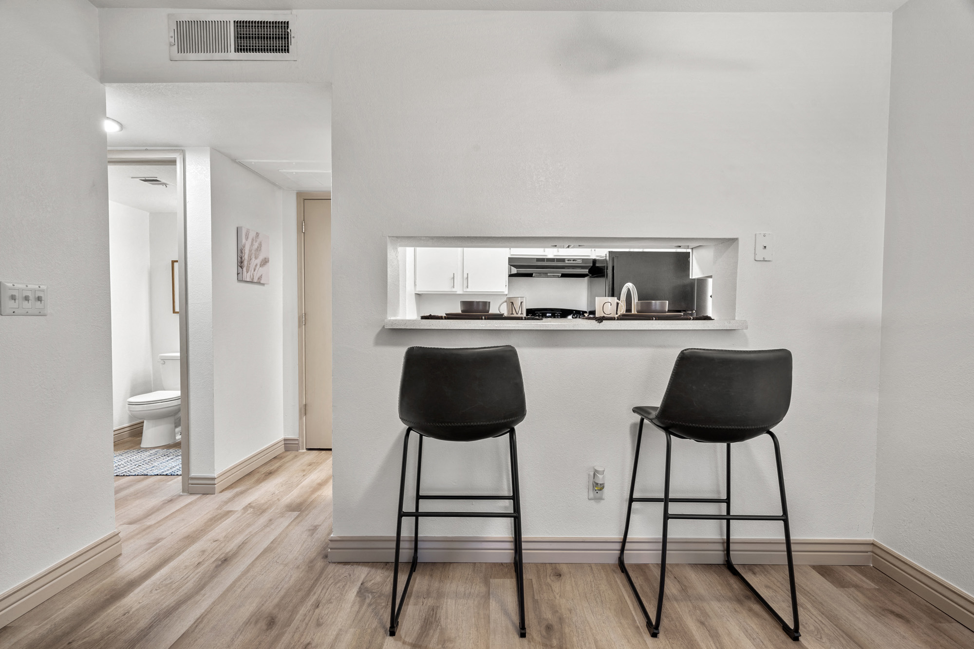Two black chairs are placed in a kitchen with a bar counter.