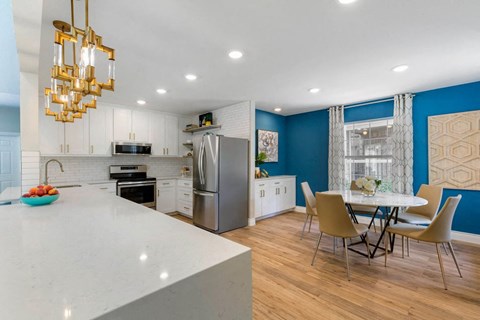 a kitchen with a large island and a table with chairs