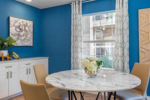 a dining room with a table and chairs and a window