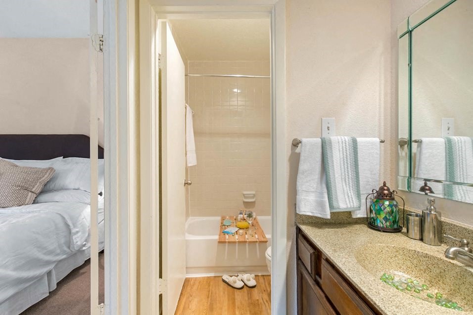 a bathroom with a sink and a shower and a bed