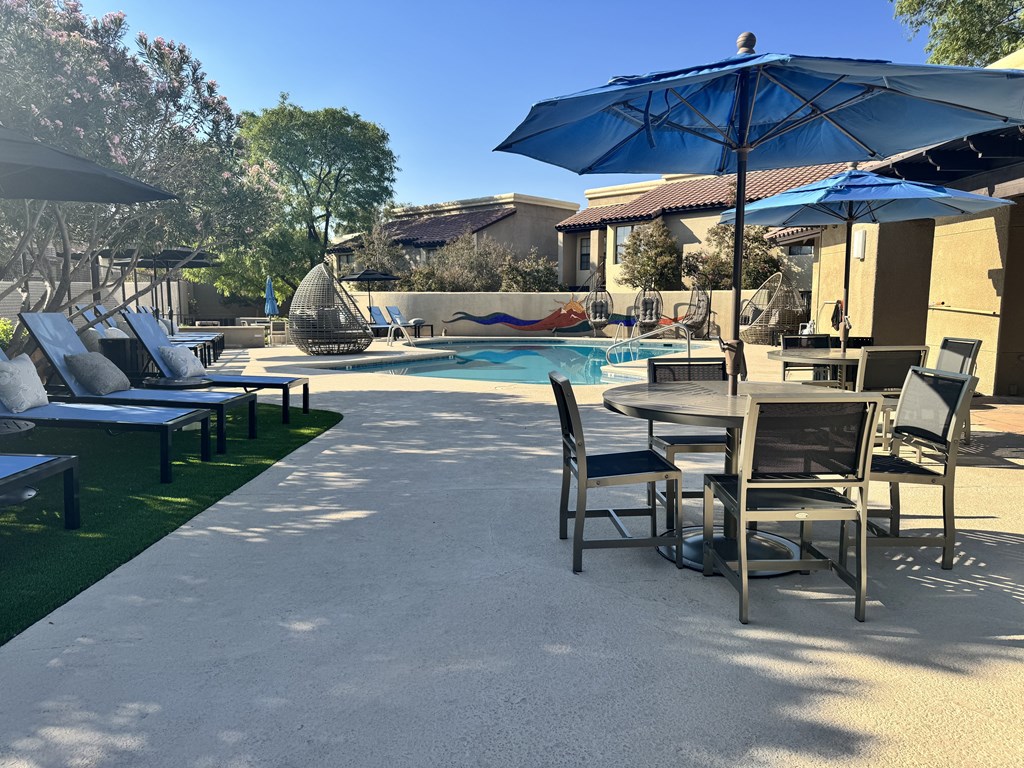 A poolside area with chairs and umbrellas.