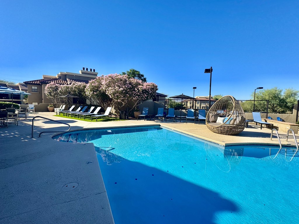 A pool with a chair and a basket on the side.