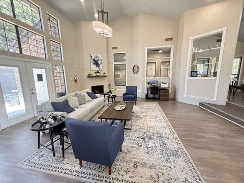 A living room with a white couch and a blue chair.