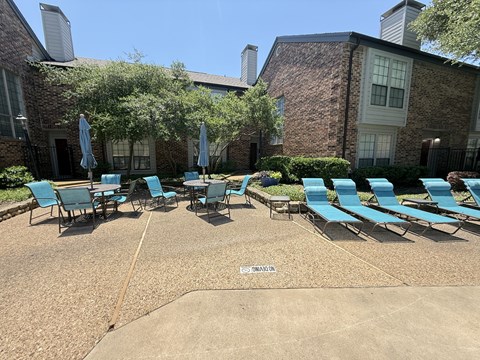 A sunny day at the pool with chairs and umbrellas.