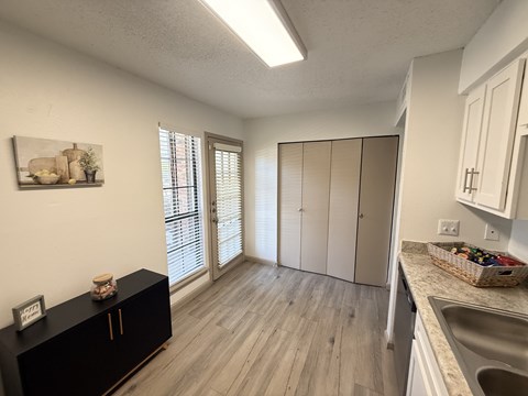A kitchen with a black cabinet and a framed picture on the wall.