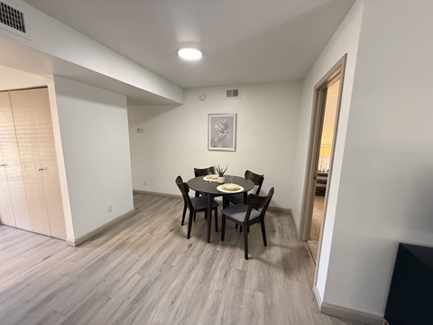 A dining room with a table and chairs.
