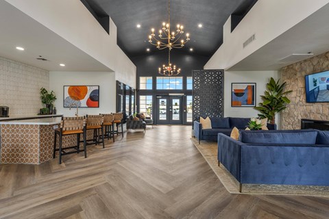 A modern living room with a blue couch and a chandelier.