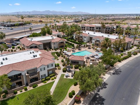 A large apartment complex with a swimming pool in the middle.