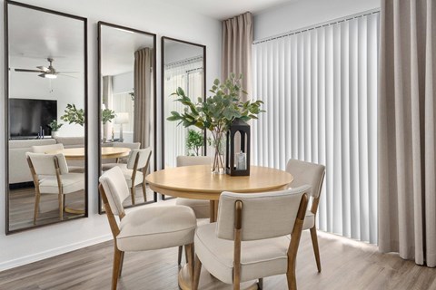 A modern dining room with a round table and chairs.