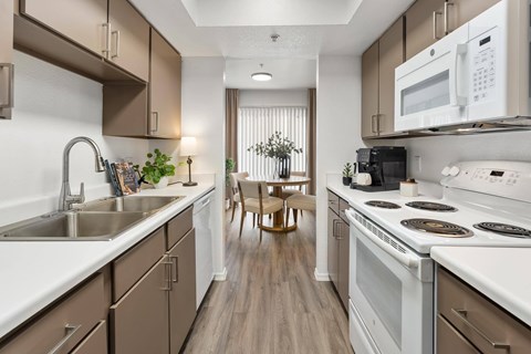 A kitchen with brown cabinets and white appliances.