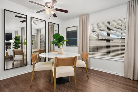 A dining room with a round table and chairs.