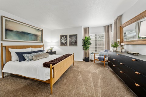 A bedroom with a large bed and a painting on the wall.