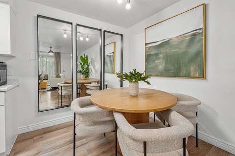 A dining room with a round table and chairs.
