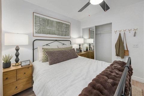 A bedroom with a white bed and a brown headboard.