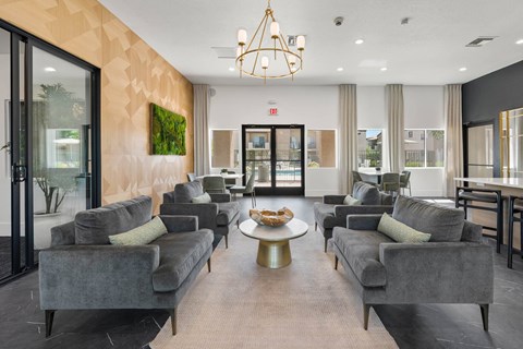 A living room with grey couches and a chandelier.