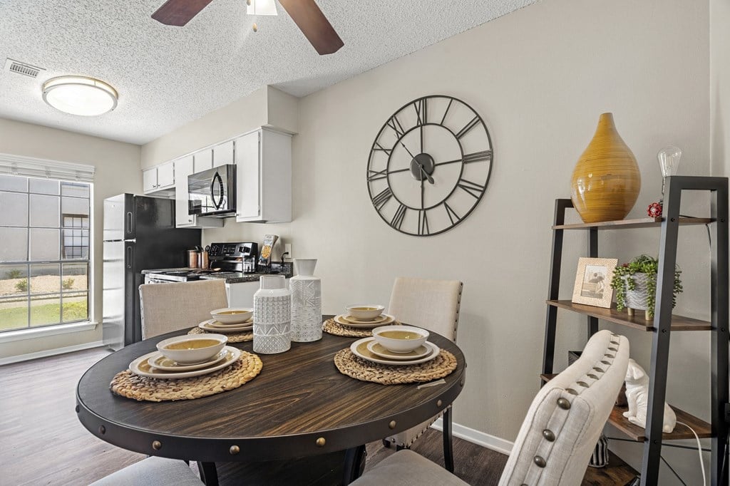A dining room with a round table set for four.
