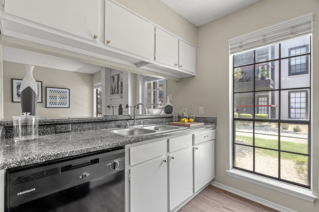 A kitchen with black appliances and granite countertops.