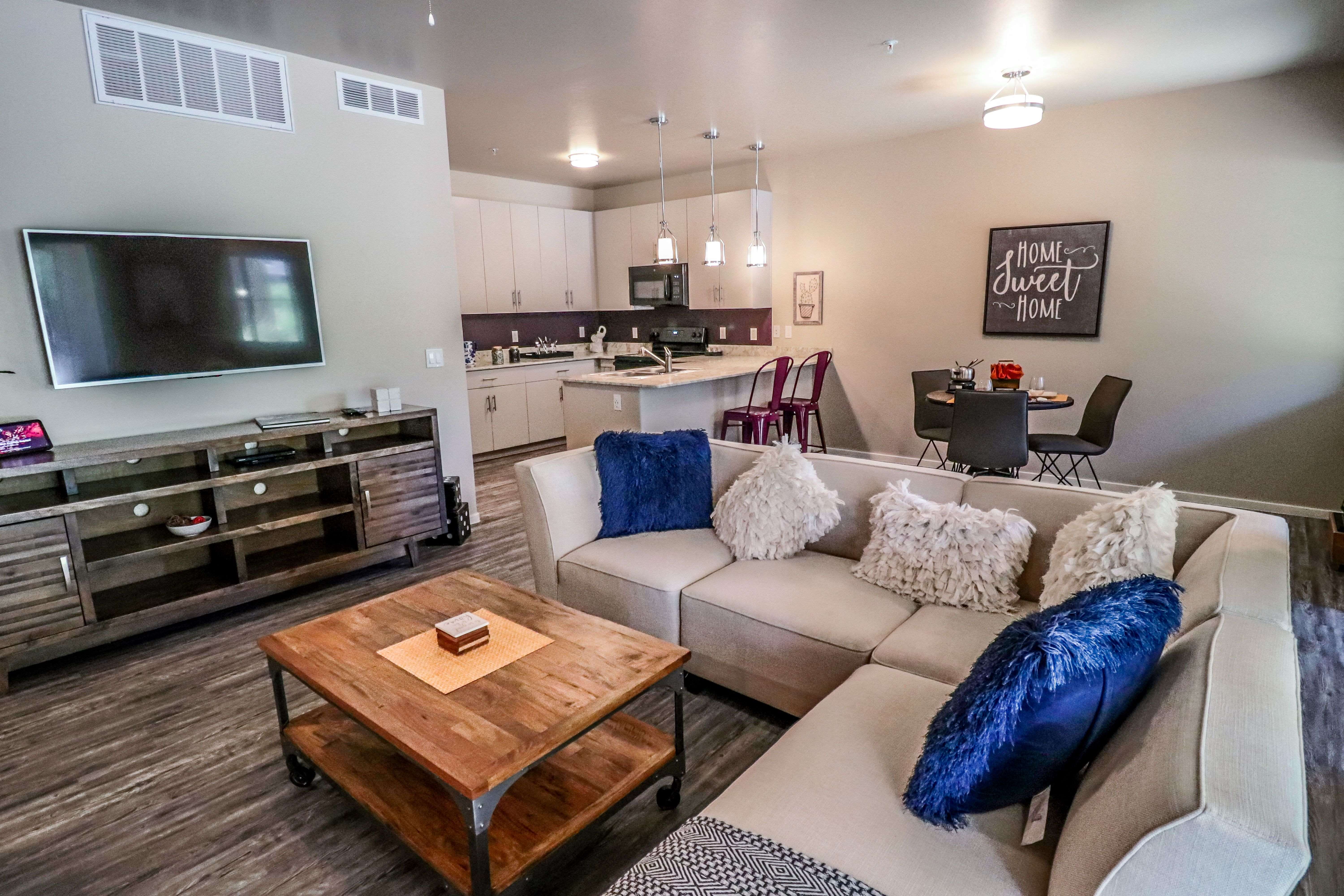 A modern living room with a wooden coffee table in the center.