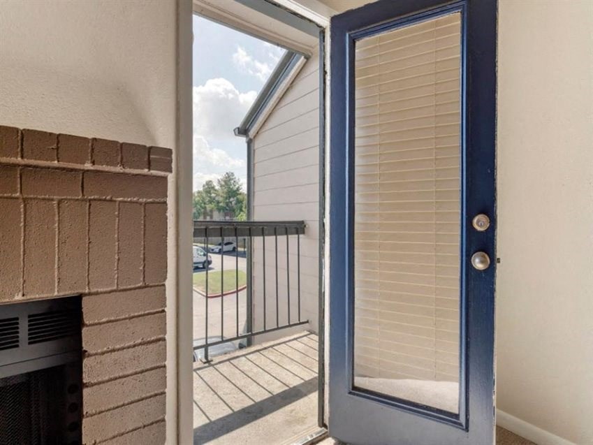 a door that is open to a balcony with a fireplace