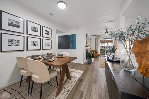 A dining room with a table set for four and a long hallway.