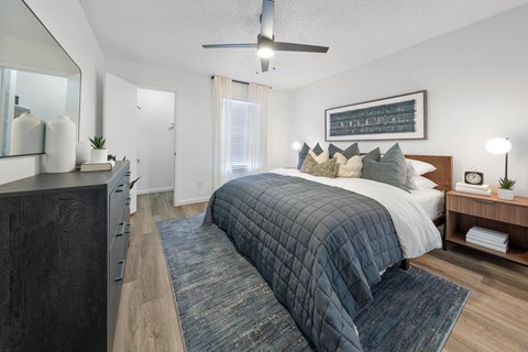 A bedroom with a large bed and a ceiling fan.