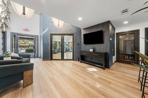 A modern living room with a grey couch and a wooden floor.