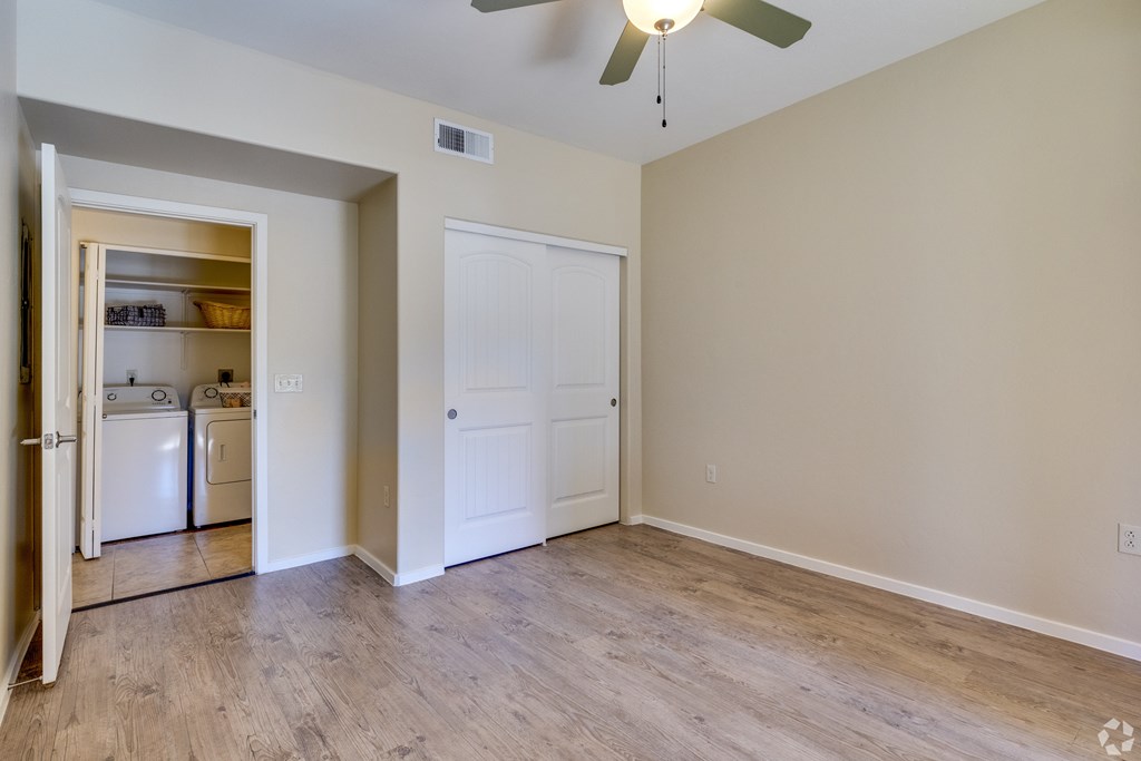 A room with a white door and a ceiling fan.