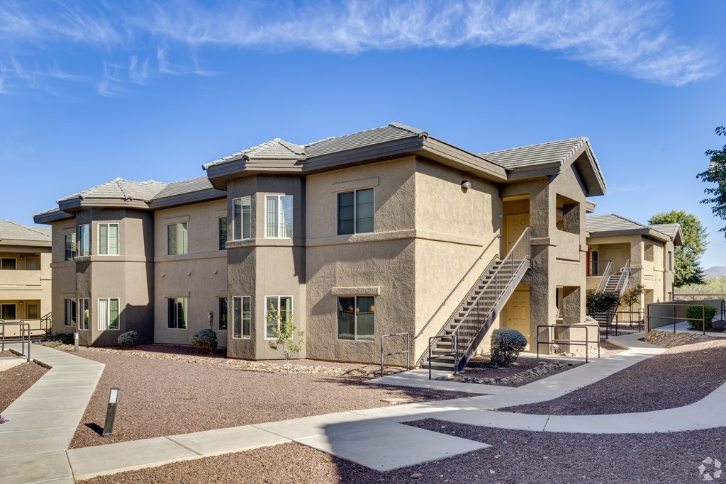A modern two-story house with a staircase leading to the entrance.
