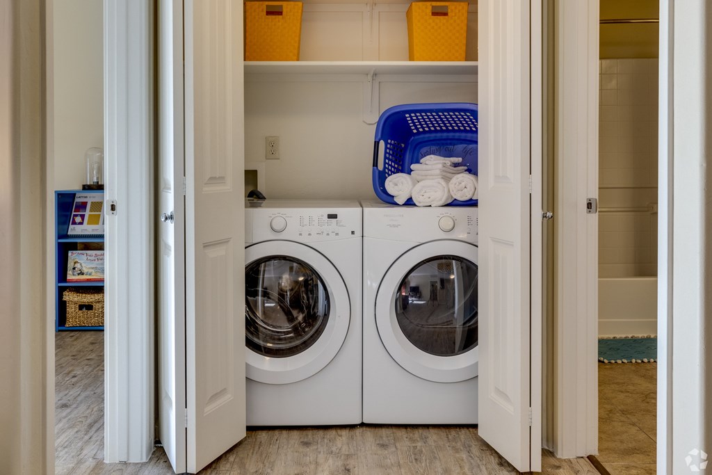 A white washer and dryer are in a small laundry room.