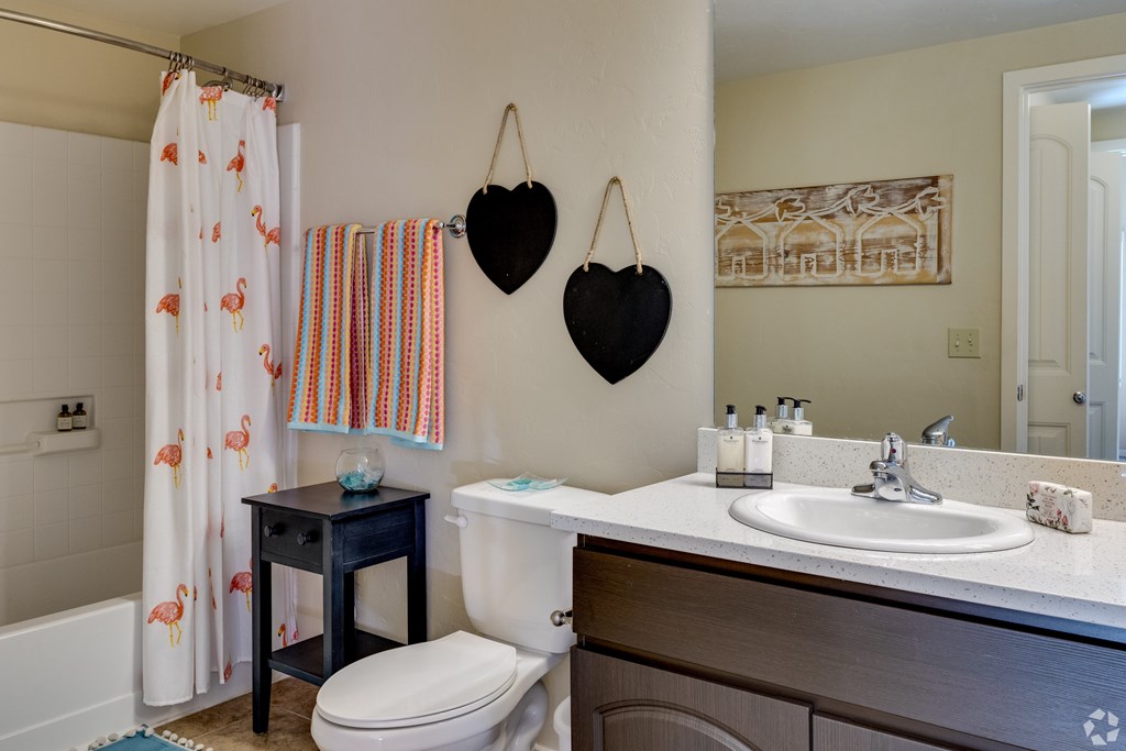 A bathroom with a toilet, sink, and shower curtain.