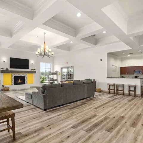 A living room with a grey couch and a fireplace.