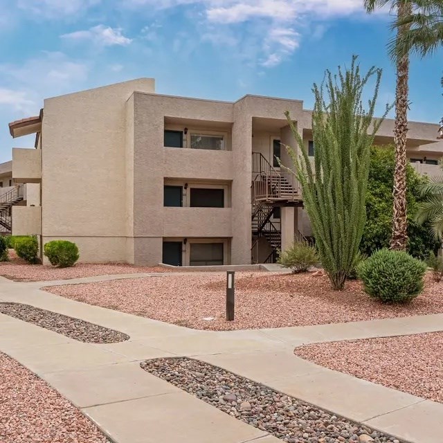 A modern building with a flat roof and a balcony on the second floor.