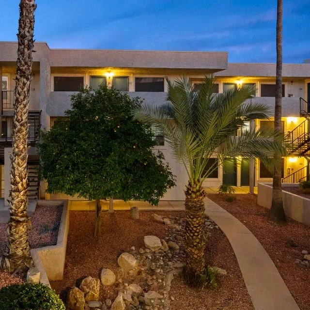 A building with a courtyard surrounded by palm trees.
