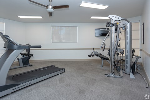A home gym with a treadmill, a stationary bike, and a multi-gym machine.
