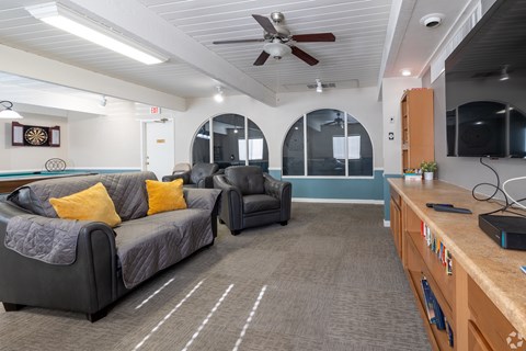 A living room with a grey couch and a black chair.