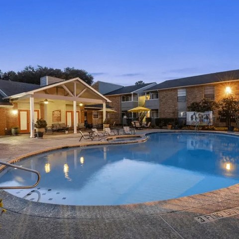 A swimming pool in a backyard with a house in the background.