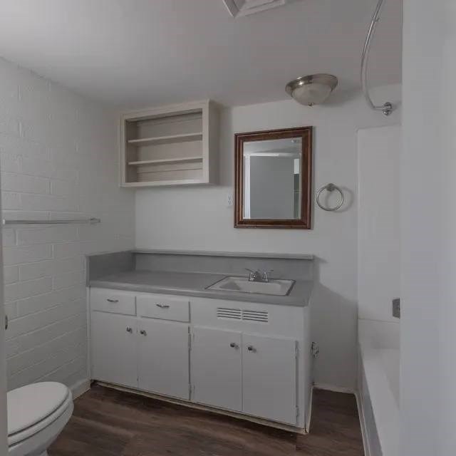 A white bathroom with a toilet, sink, and mirror.