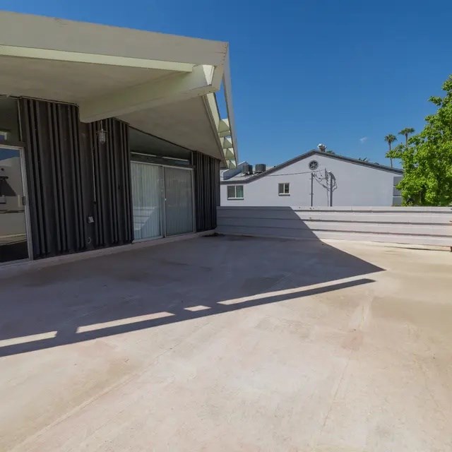 A modern house with a flat roof and a covered patio area.