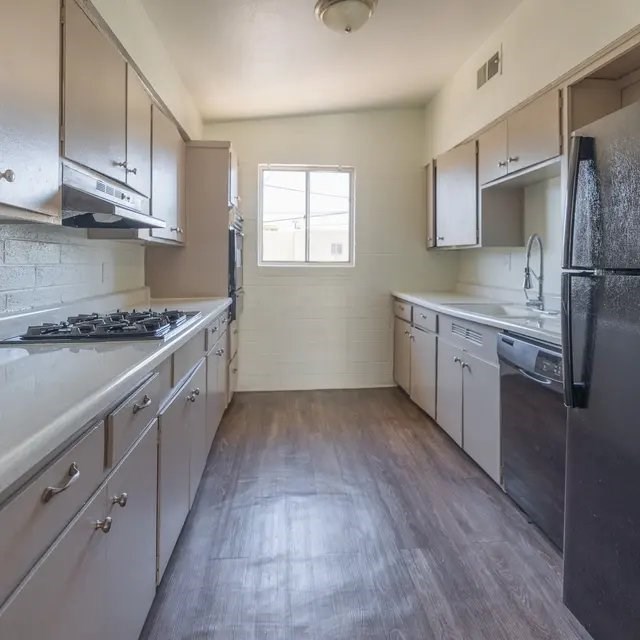 A kitchen with a black stove top oven and a black refrigerator.