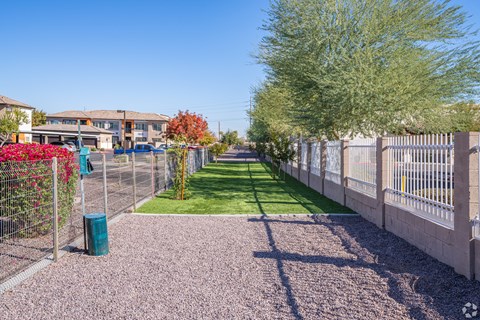 A residential area with a fence and a green lawn.