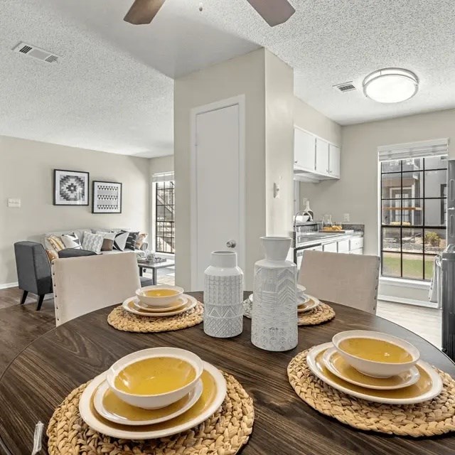 A dining table set with plates and bowls of soup.