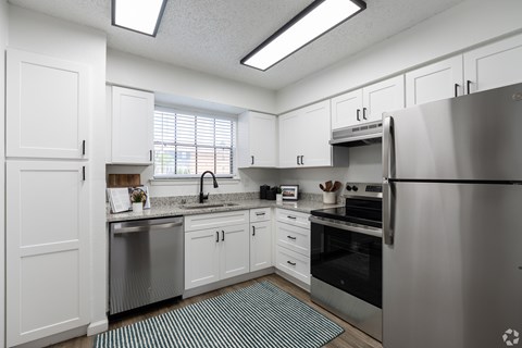 A kitchen with white cabinets and stainless steel appliances.