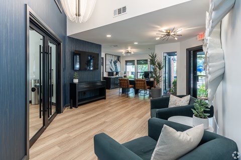 A living room with a grey couch and a wooden floor.