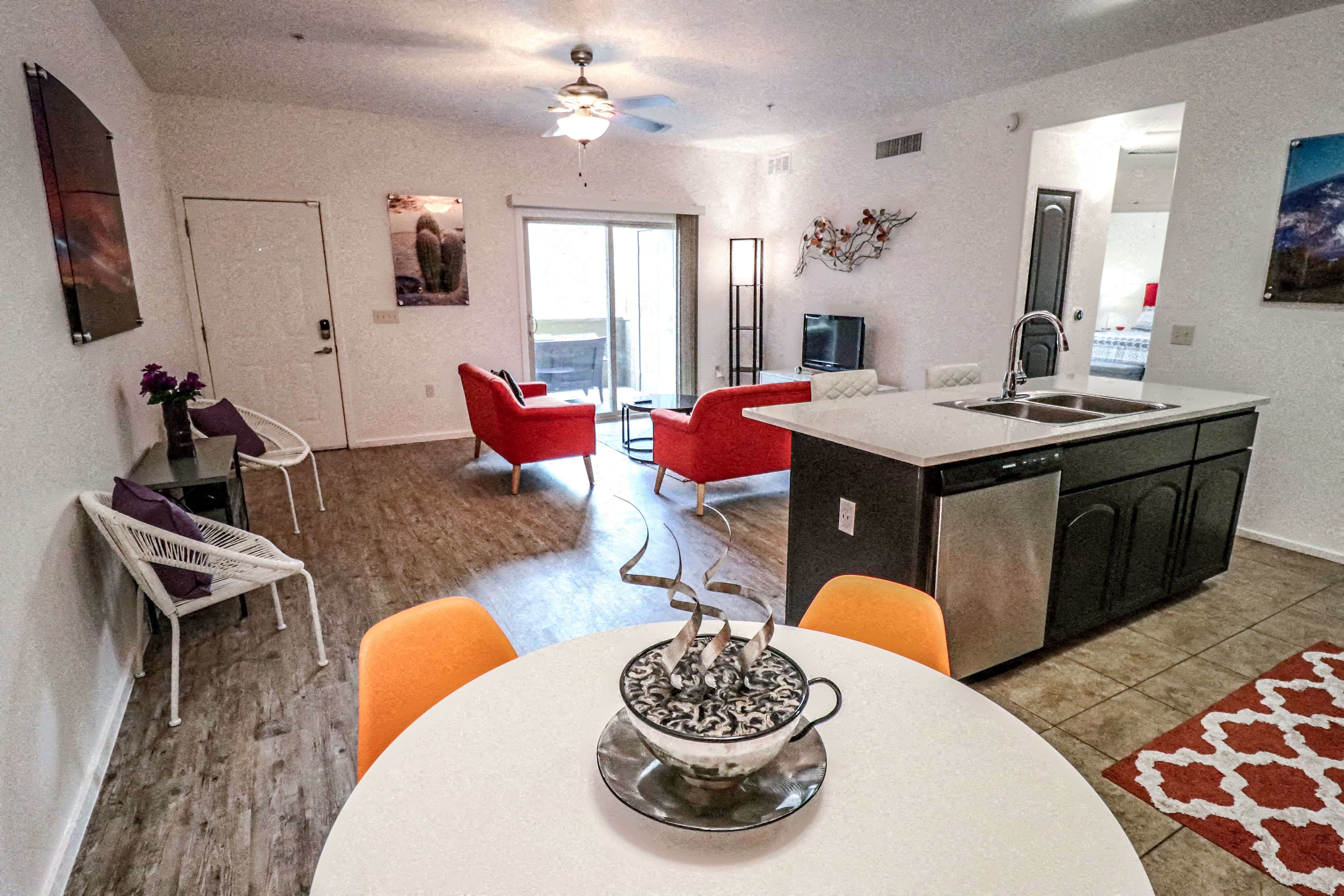 A modern kitchen and dining area with a white table and chairs.