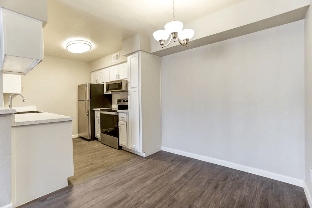 A kitchen with a refrigerator, oven, and microwave.