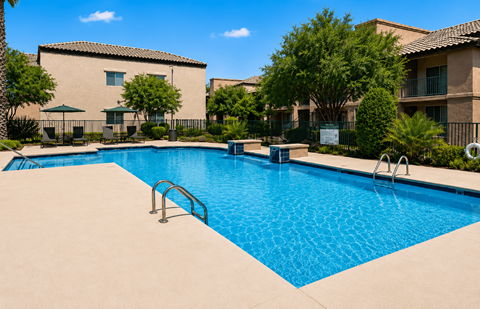 A swimming pool surrounded by a fence and trees.