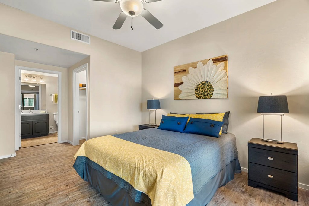 A bedroom with a bed, nightstand, and lamp.