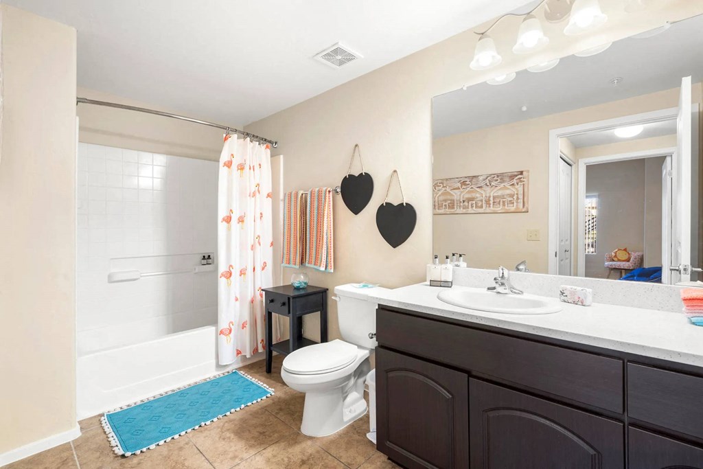 A bathroom with a toilet, sink, and shower.