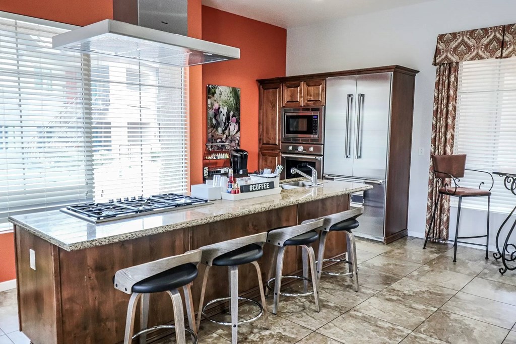 A kitchen with a large island and stools.